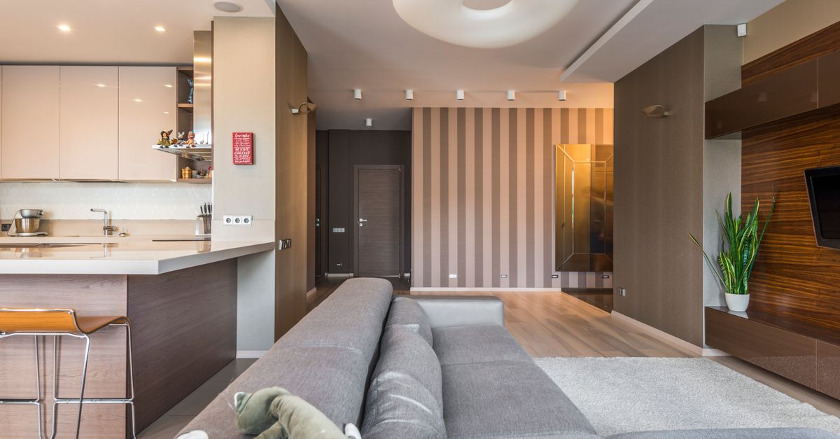 Spacious living room with a modern, minimalist design and open kitchen layout.